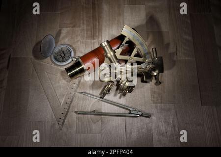 vecchio sestante, spyglass, cerchio e bussola giacente su un tavolo di legno Foto Stock