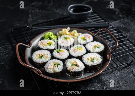 Gimbap Kimbap ripieno di verdure, uova, acciughe e granchio, rotolo di riso coreano. Sfondo nero. Vista dall'alto. Foto Stock