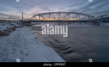 Alba invernale sul fiume Bow e un ponte a Cochrane, Alberta, Canada Foto Stock