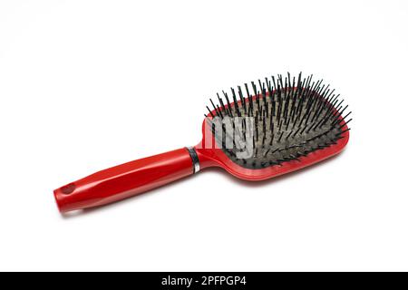 vecchia spazzola rossa per capelli con capelli che si stacca. pettinare con i capelli. Foto di alta qualità Foto Stock