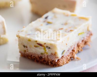 Piatto bianco pieno di dolci diversi. Gustosi dessert con farcitura, pistacchi. Foto Stock