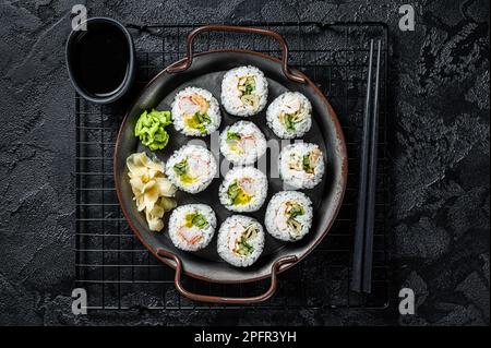 Gimbap Kimbap ripieno di verdure, uova, acciughe e granchio, rotolo di riso coreano. Sfondo nero. Vista dall'alto. Foto Stock