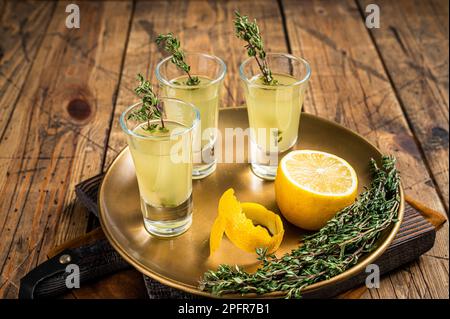 Shot di limoncello, liquore di limone italiano. Sfondo di legno. Vista dall'alto. Foto Stock