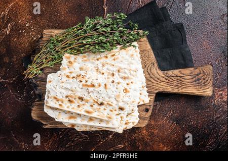 Felice concetto di Pasqua, matzah su una tavola di legno. Sfondo scuro. Vista dall'alto. Foto Stock