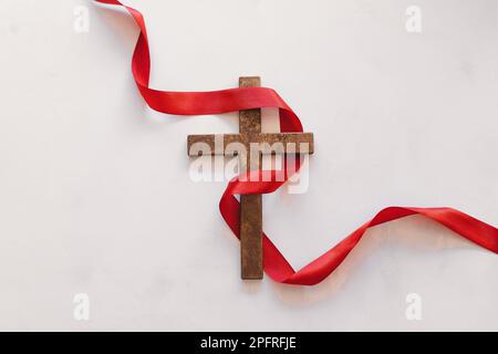 Croce con un nastro rosso, un simbolo di Cristo. Crocifissione di Gesù Cristo. Pasqua Foto Stock