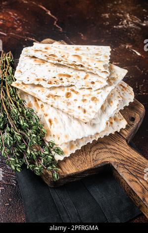 Felice concetto di Pasqua, matzah su una tavola di legno. Sfondo scuro. Vista dall'alto. Foto Stock