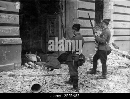 Nel gennaio del 1943 i nazisti arrivarono per arrotondare gli ebrei del ghetto di Varsavia gli ebrei, decisi a combatterlo, presero le SS con armi fatte in casa e primitive. I difensori furono giustiziati o deportati e la zona del Ghetto fu sistematicamente demolita. Questo evento è noto come la rivolta del Ghetto. Questa immagine mostra i corpi degli ebrei giustiziati dopo la loro cattura. Questa immagine è tratta dal record fotografico tedesco dell'evento, noto come rapporto Stroop. Foto Stock