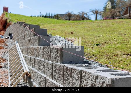 Edificio che trattiene muro che è in costruzione sulla proprietà vicino a nuova casa come parte della costruzione di nuova casa Foto Stock