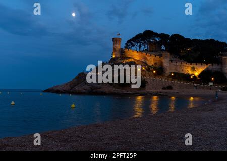 Tossa de Mar, Spagna - il castello illuminato domina la spiaggia, creando un'atmosfera magica di notte Foto Stock