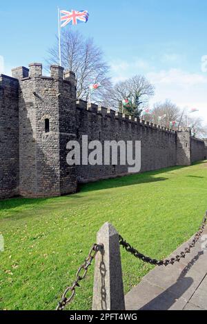 Mura esterne del castello di Cardiff con bandiere gallesi e unionarie che volano. Marzo 2023. Foto Stock