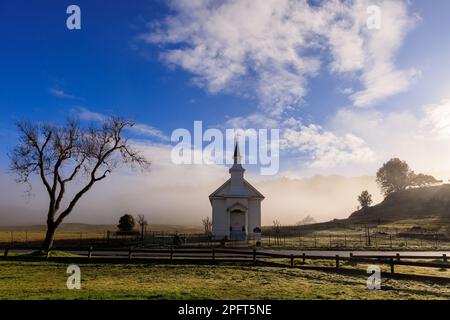 Bassa nebbia dietro la piccola chiesa rurale nella contea di Marin, California all'alba Foto Stock