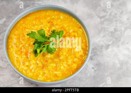 Ciotola di zuppa di lenticchie su cemento. Zuppa di lenticchie rosse con prezzemolo fresco. Piatto tradizionale turco o arabo. Spazio di copia. Vista dall'alto Foto Stock