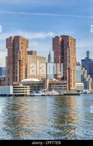 La guglia iconica del Chrysler Building, incorniciata dalle torri di mattoni di Waterside Plaza, dal concrete Bellevue Hospital Center e dal vetro blu Alexandria Center. Foto Stock