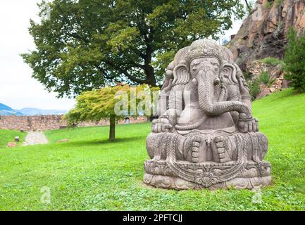 Ganesha statua, in pietra, con un bellissimo giardino con vista sulle montagne in background Foto Stock