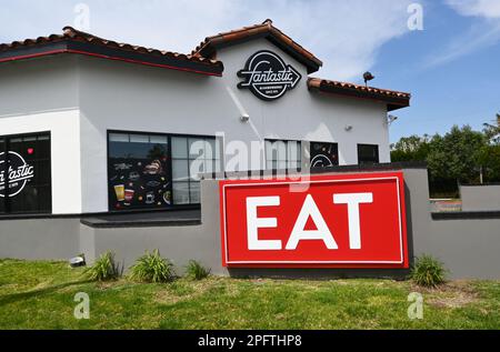 TUSTIN, CALIFORNIA - 17 MAR 2023: Fantastico ristorante fast food hamburger con un grande cartello PER MANGIARE davanti. Foto Stock