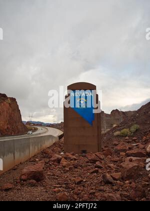 Blue Nevada Welcome Sign sull'autostrada US 93 presso la diga di Hoover in una giornata di pioggia nuvolosa e scura. Monumento nazionale Foto Stock