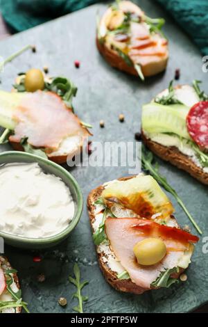 Tavola con deliziosi panini e formaggio spalmabile, primo piano Foto Stock