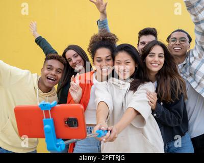 Gruppo di giovani millennial diversi prendere un selfie divertirsi. Concetto di comunità e di amicizia Foto Stock