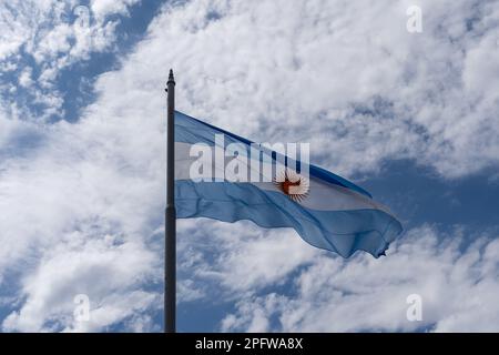 La bandiera nazionale della Repubblica argentina con cielo blu e nuvole bianche sullo sfondo. Foto Stock