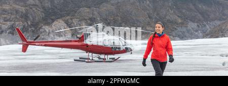 Pilota di elicotteri donna che cammina sul ghiacciaio escursionista in Alaska dopo aver volato l'aereo in aria. Banner panoramico destinazione di viaggio USA Foto Stock