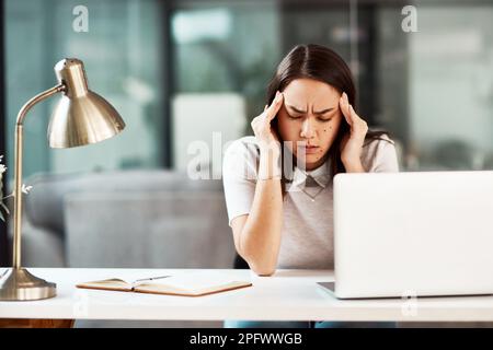 Sensazione di agitazione e ansia. una giovane donna d'affari che soffre di mal di testa mentre lavora in un ufficio. Foto Stock