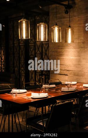 Posti a sedere all'interno del ristorante di notte Foto Stock