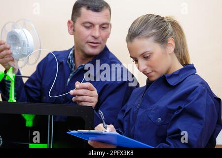 tecnici maschili e femminili che lavorano con la stampante 3d Foto Stock