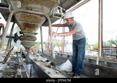 lavoratore di pianta di fabbrica di cemento che svuota il mescolatore Foto Stock