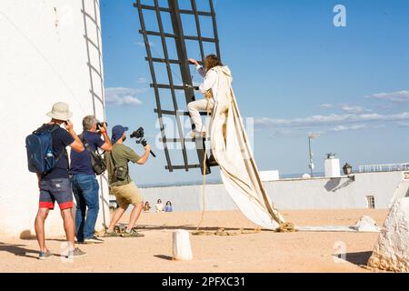 Campo de Criptana, Spagna - 22 giugno 2022: Mulino a vento con l'uomo che sale sulle pale per installare il panno per farlo funzionare e fotografi e video ma Foto Stock