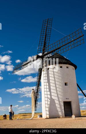 Campo de Criptana, Spagna - 22 giugno 2022: Mulino a vento con l'uomo che sale sulle pale per installare il tarpo per farlo funzionare Foto Stock