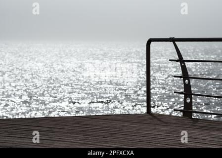 Paesaggio costiero mattutino. Riflesso solare nell'acqua di mare. Nebbia mattutina Foto Stock