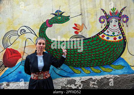 Una donna armena, Melike Dara, cittadina turca, è vista facendo un segno di vittoria davanti ad un dipinto disegnato su un muro in una strada a Diyarbakir. Il popolo curdo che vive in Turchia, Iraq, Iran e Siria in Medio Oriente celebra Newroz, la vacanza primaverile. Mentre alcuni altri popoli pre-asiatici celebrano anche questa vacanza con feste, i curdi celebrano Newroz come una festa nazionale con picnic, balli, e intrattenimento musicale basato su una leggenda in History.However, i curdi della Turchia sono stati combattendo politicamente e armati per il riconoscimento legale della identità curda f Foto Stock