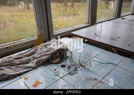 Tavoli vecchi e fatiscenti e tavolini da caffè in un edificio abbandonato. Foto Stock