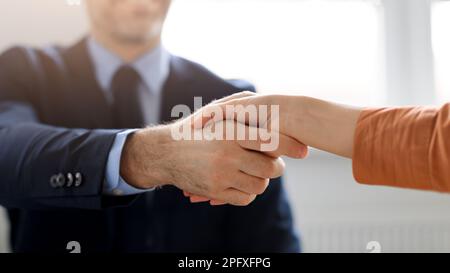 Partnership commerciale. Imprenditori maschili e femminili che scuotono le mani, celebrando l'accordo di cooperazione in carica, tagliato Foto Stock