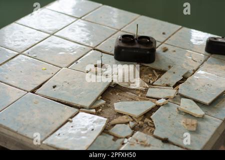 Tavoli vecchi e fatiscenti e tavolini da caffè in un edificio abbandonato. Foto Stock