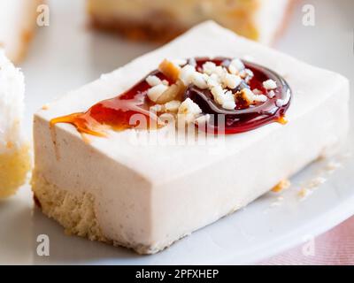 Piatto bianco pieno di dolci diversi. Gustosi dessert con farcitura, fiocchi di cocco. Foto Stock