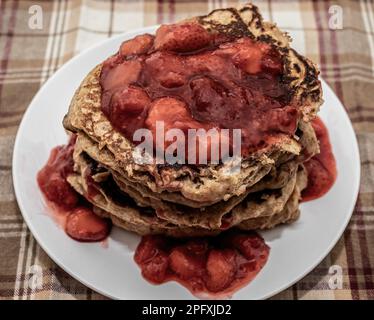 Frittelle di siero di latte intero condite con salsa di fragole su una tovaglia a platea a Taylors Falls, Minnesota USA. Foto Stock