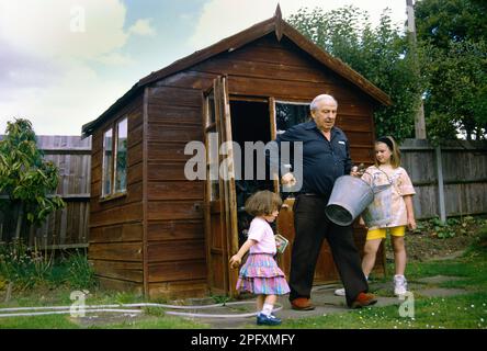 Nonno in giardino di Shed con i nipoti Surrey Inghilterra Foto Stock