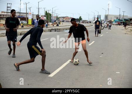 Lagos, Nigeria, 18 marzo 2023 i giovani giocano a calcio lungo la Lagos-Abeokuta Expressway durante il Governatorato e la Camera di Stato dell'Assemblea del 2023 ad Alusa, Ikeja, Lagos, Nigeria, il sabato, Marzo 18, 2023. Credit: Adekunle Ajayi/Alamy Live News Foto Stock