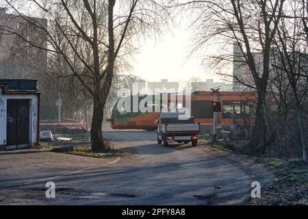 Servizio di costruzione e manutenzione di strade ferroviarie pick-up camion auto all'incrocio con binari ferroviari su una strada di periferia circondata da alberi Foto Stock