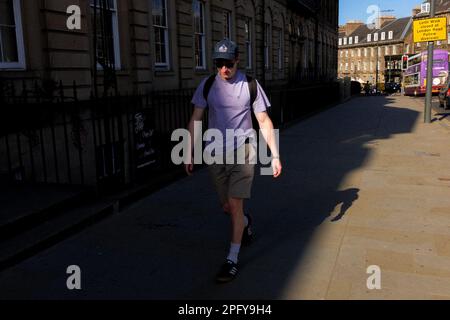 Giovane uomo che cammina su una strada a Edimburgo - Scozia, Regno Unito Foto Stock