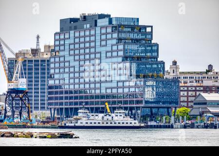 Il molo 72, un alto edificio commerciale con pareti in vetro blu nell'ex Brooklyn Navy Yard, è anche uno sbarco in traghetto sull'East River. Foto Stock