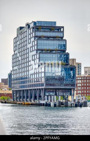 Il molo 72, un alto edificio commerciale con pareti in vetro blu nell'ex Brooklyn Navy Yard, è anche uno sbarco in traghetto sull'East River. Foto Stock