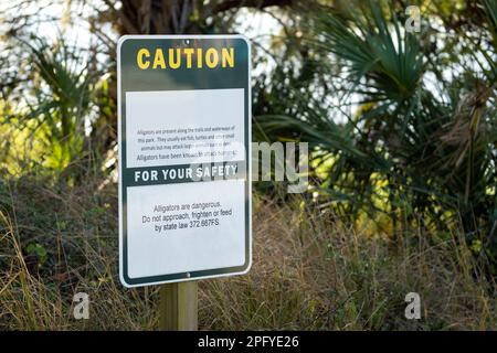 Alligatori segnale di avvertimento nel parco statale della Florida per la prudenza e la sicurezza durante il percorso a piedi Foto Stock