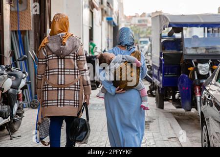 Due donne che camminano per strada con un bambino a Fes Foto Stock