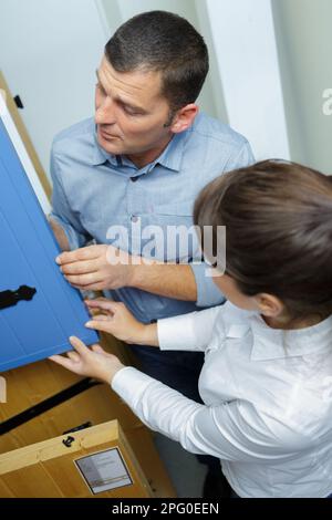 clienti giovani e positivi che scelgono la facciata della cucina in negozio Foto Stock