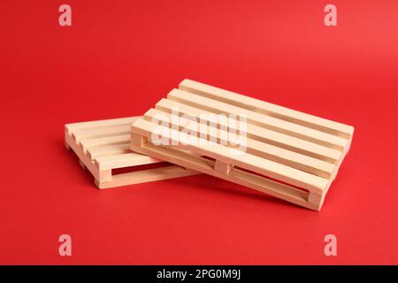 Due piccoli pallet in legno su sfondo rosso Foto Stock