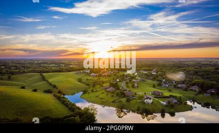 Vista aerea panoramica del tramonto sul quartiere rurale e un lago nel Kentucky centrale Foto Stock