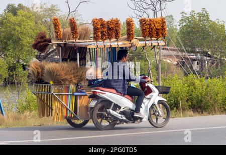 BANGKOK, THAILANDIA, MAR 11 2023, Un venditore di scope cavalca una moto con un sidecar Foto Stock