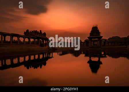 Tramonto sul lago Pushkarani vicino al tempio Vijaya Vitthala a Hampi. Hampi, la capitale dell'impero Vijayanagar, è un sito patrimonio dell'umanità dell'UNESCO. Foto Stock